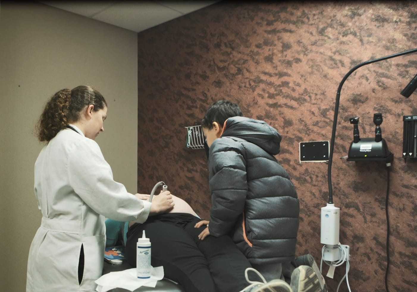OB physician with mother and newborn in the maternity unit
