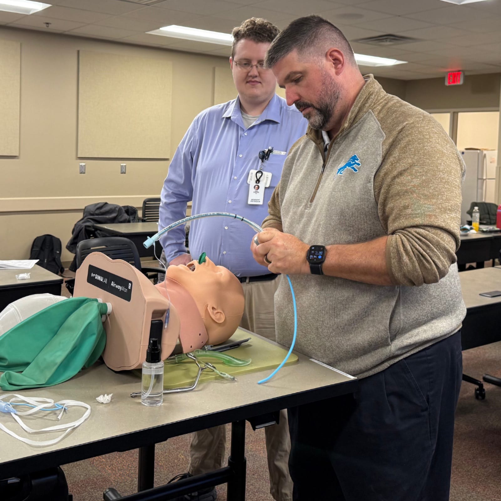 A resident and faculty member rehearsing airway management and intubation on a high-fidelity manikin